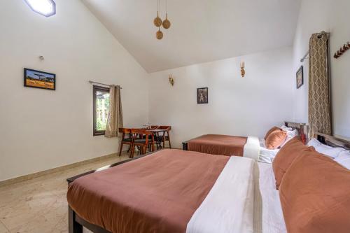 a bedroom with two beds and a table in it at Interlaken in Yedapalli