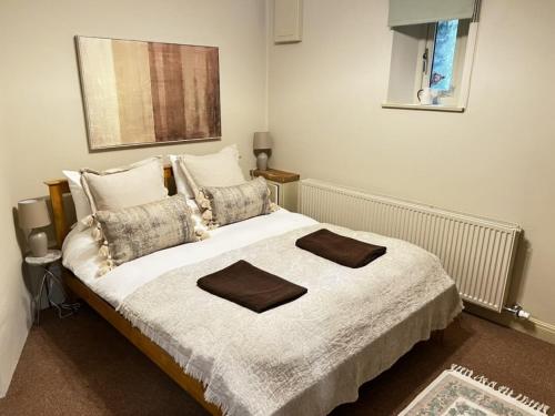 a bedroom with a bed with two towels on it at Kilnsey Wellbeing Barn With Hot Tub, Cold Plunge, Pet Friendly in Kilnsey