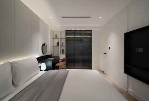 a bedroom with a large bed and a television at The28 Residence in Hanoi