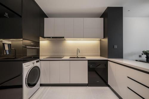a kitchen with white cabinets and a dishwasher at The28 Residence in Hanoi