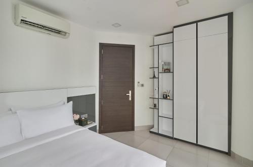 a bedroom with a large white bed and a closet at Noden Hotel & Apartment in Phnom Penh