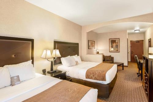 a hotel room with two beds and a desk at Comfort Suites Moses Lake in Moses Lake