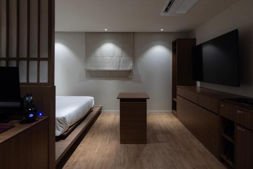 a bedroom with a bed and a flat screen tv at Aank Ryokan Hotel Ansan Seonbu Branch in Ansan