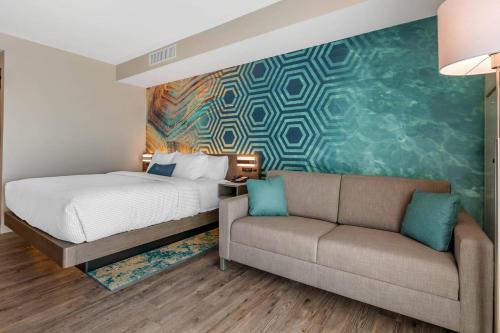 a bedroom with a bed and a couch at Cambria Hotel St Petersburg-Madeira Beach Marina in St Pete Beach