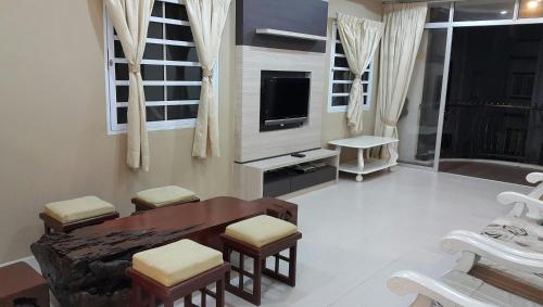 a living room with a table and a tv at Rose Apartment Kea Farm in Cameron Highlands
