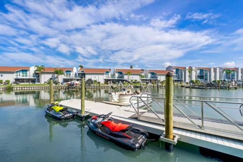 two boats are docked at a dock in the water at Cambria Hotel St Petersburg-Madeira Beach Marina in St Pete Beach