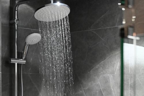 a shower with a shower head in a bathroom at Clarion Hotel Jeddah Airport in Jeddah