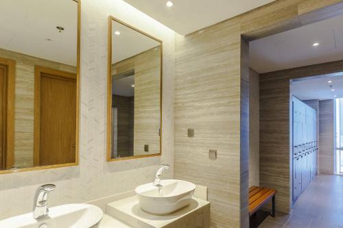 a bathroom with two sinks and a mirror at Clarion Hotel Jeddah Airport in Jeddah