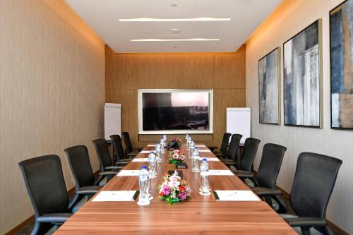 a conference room with a long table and chairs at Clarion Hotel Jeddah Airport in Jeddah