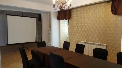 a conference room with a table and a projection screen at Hotel Coroana Moldovei in Slănic-Moldova