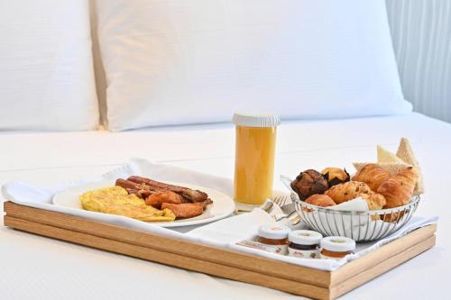a breakfast tray with breakfast foods on a bed at Clarion Hotel Jeddah Airport in Jeddah