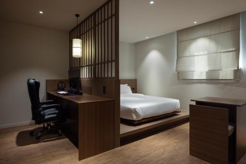 a bedroom with a bed and a desk and a chair at Aank Ryokan Hotel Ansan Seonbu Branch in Ansan