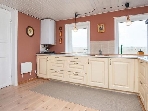 an empty kitchen with white cabinets and two windows at 6 person holiday home in Harboøre-By Traum in Harboør