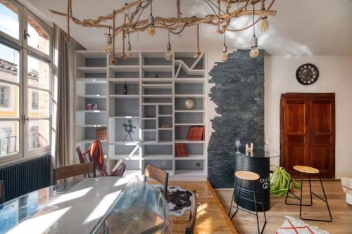 a dining room with a table and a brick wall at L'élite Montauban calme et spacieux in Montauban