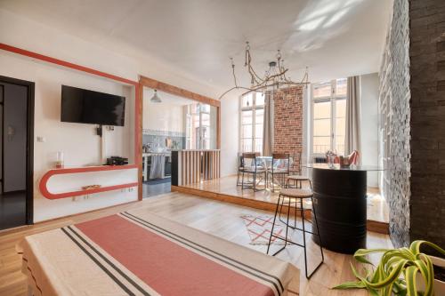 a living room with a table and a dining room at L'élite Montauban calme et spacieux in Montauban