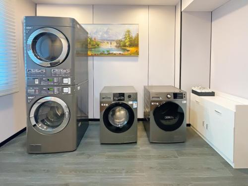 three washing machines and a washer and dryer in a room at Crystal Orange Hotel Shanghai International Tourism Resort Chuansha in Shanghai