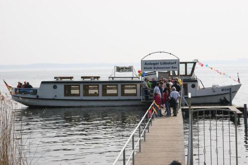 a group of people boarding a boat at a dock at Gasthaus Zum Rethberg in Lübstorf