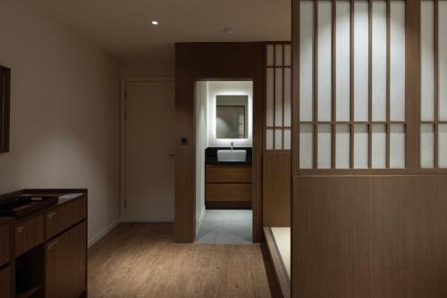 a room with a hallway with a sink and a mirror at Aank Ryokan Hotel Ansan Seonbu Branch in Ansan