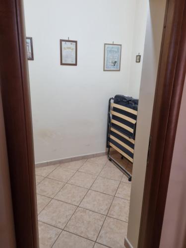 a hallway with a tile floor and two pictures on the wall at La perla marina in Cellole