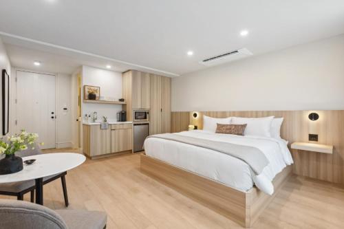 a bedroom with a large white bed and a table at Casa Riviera - Boutique Suites in Downtown Santa Barbara in Santa Barbara