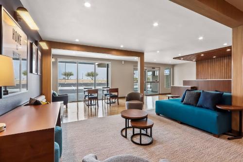 a living room with a blue couch and a table at Everhome Suites El Paso Airport near Fort Bliss by Choice Hotels in El Paso