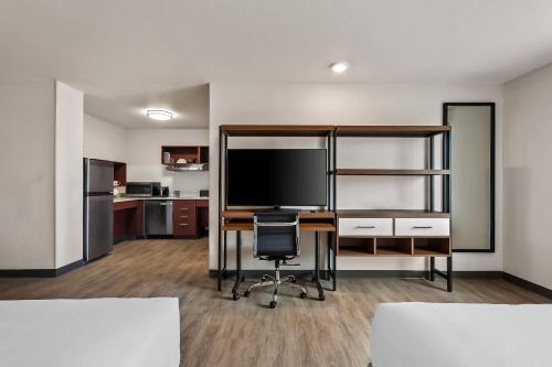 an office with a desk and a television in a room at Everhome Suites El Paso Airport near Fort Bliss by Choice Hotels in El Paso