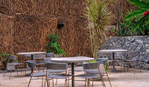 a group of tables and chairs in front of a wall at V Grand Hotel, a member of Radisson Individuals in Medellín