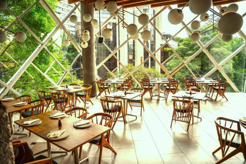 an empty restaurant with tables and chairs in a building at V Grand Hotel, a member of Radisson Individuals in Medellín