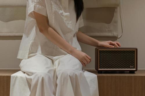 a woman in a wedding dress sitting next to a radio at Aank Ryokan Hotel Ansan Seonbu Branch in Ansan