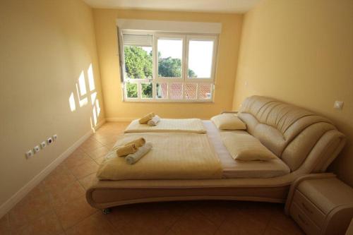 a large bed in a room with a window at Apartments Villa Astra & Pinija in Brela