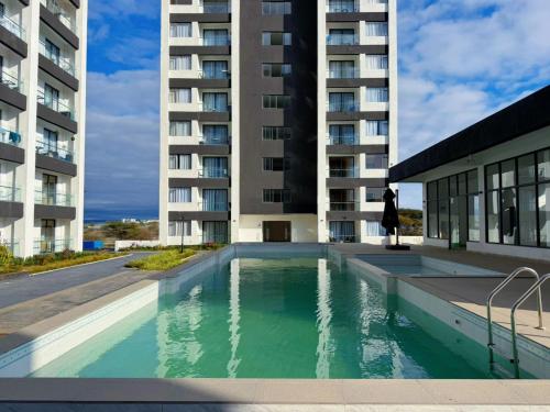 a swimming pool in front of a building at Artesano Park View Furnished Apartment in Nairobi