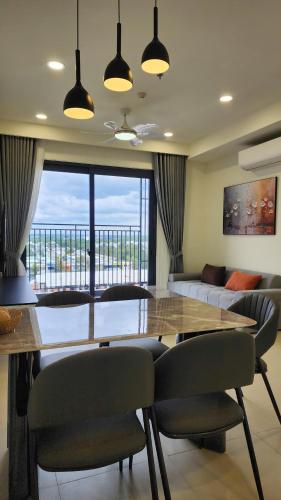 a living room with a table and chairs and a couch at Homie's The Glory Apartment in Thu Dau Mot