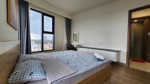 a bedroom with a large bed and a large window at Homie's The Glory Apartment in Thu Dau Mot