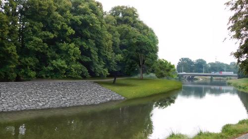 a river with trees and a bridge in the background at Apartment Holata 201 in Hradec Králové