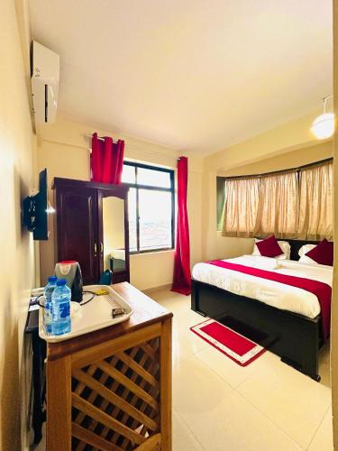 a hotel room with a bed and a table in a room at Queen Hotel in Morogoro