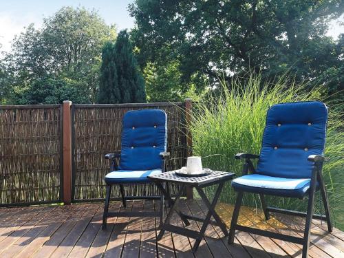 two blue chairs and a table on a deck at 5 person holiday home in Tranekær-By Traum in Tranekær