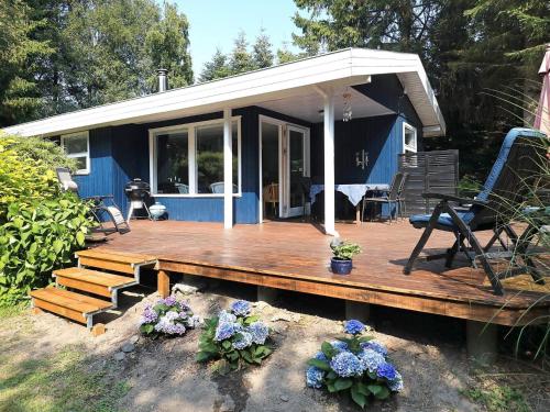 a small blue house with a wooden deck at 5 person holiday home in Tranekær-By Traum in Tranekær