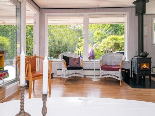 a living room with three chairs and a wood stove at 5 person holiday home in Tranekær-By Traum in Tranekær