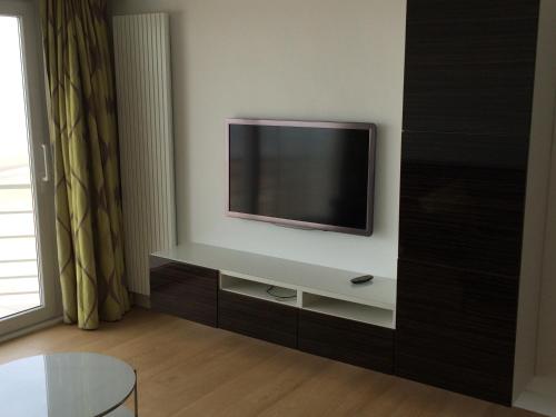 un soggiorno con una TV a schermo piatto su una parete di Splendid 0705 a De Panne