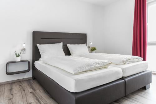ブルガウにあるBusiness and Family Homesの白い壁のベッドルームにツインベッド2台が備わります。