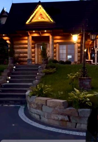 a log home with a set of stairs in front at Domek Tatrzańska Zyngierka z Jacuzzi in Ząb