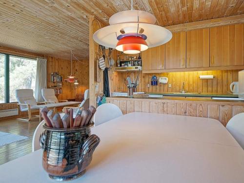 a kitchen with a table with a vase on it at 6 person holiday home in Nexø in Vester Sømarken