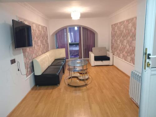 een woonkamer met een bank en een tafel bij Центр in Baku