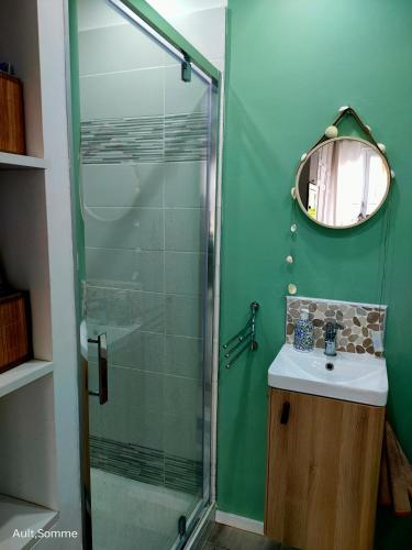 a bathroom with a sink and a glass shower at La parenthèse in Ault