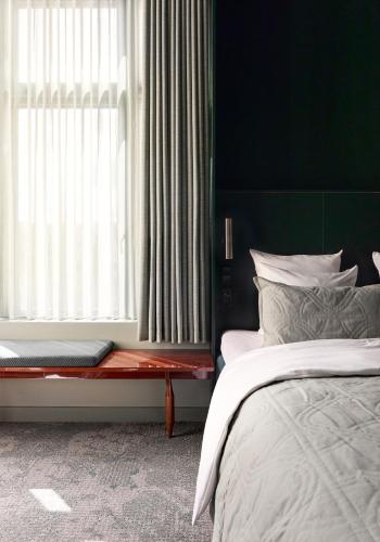 a bedroom with a bed and a large window at Hotel Hans in Copenhagen
