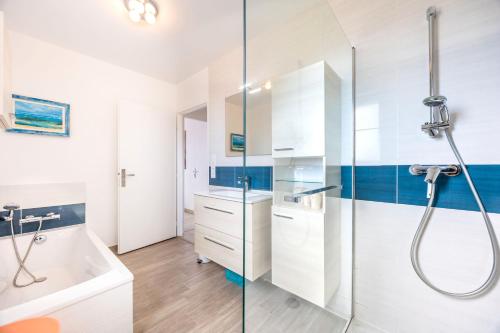 a bathroom with a shower and a tub and a sink at La Maison du Payré - proche plages in Talmont-Saint-Hilaire