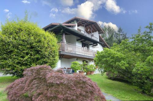 a house with a balcony and some bushes at Villa La Verbanina Private Garden - Happy Rentals in Ghiffa
