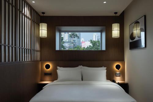 a bedroom with a white bed and a window at Aank Ryokan Hotel Ansan Seonbu Branch in Ansan