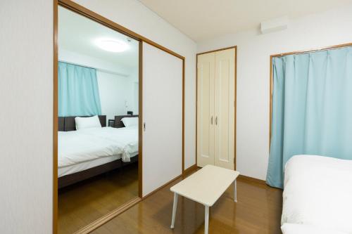 a mirror in a bedroom with a bed and a table at Mary's in Ohori Pleasing in Fukuoka