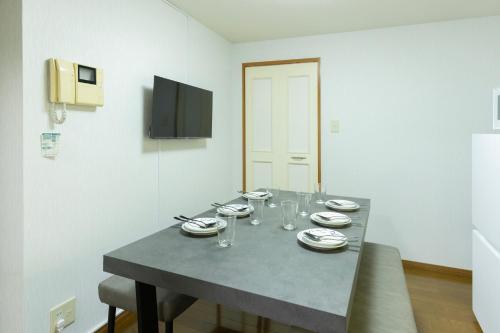 a dining room table with plates and wine glasses at Mary's in Ohori Pleasing in Fukuoka